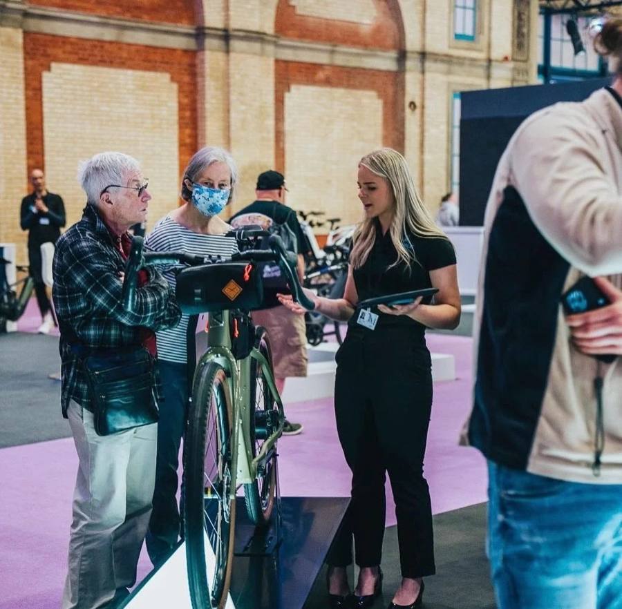 Holly demonstrating a bike to visitors at a cycling exhibition