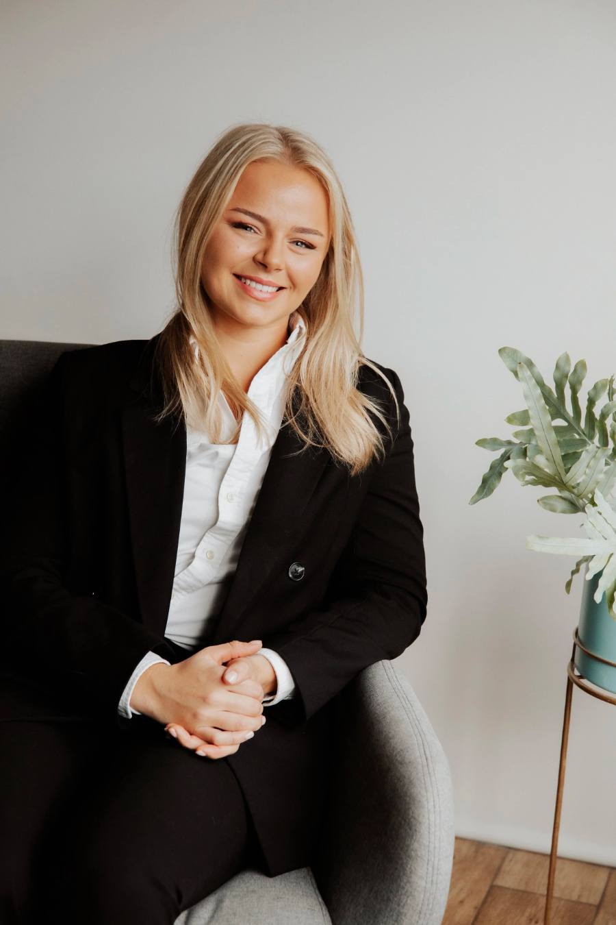 Holly James, founder of James & Co., smiling in an armchair