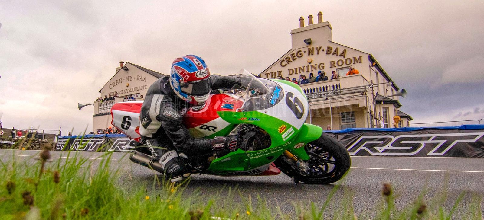 Sponsored rider cornering on a road race circuit